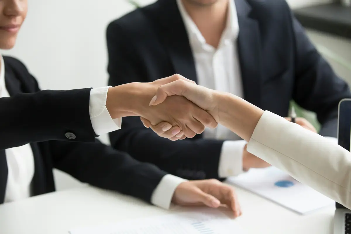 Zwei Menschen geben sich per Handschlag die Hand als Zeichen von Vertrauen
