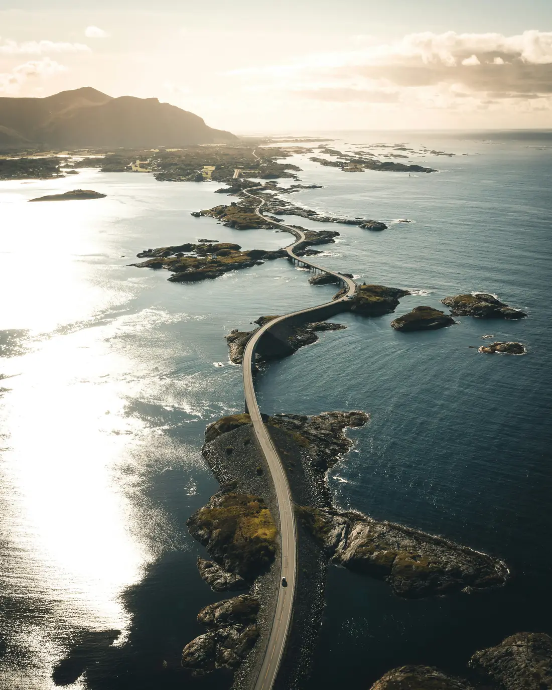 Kurvige Küstenstraße über Felsinseln in Norwegen bei Sonnenlicht
